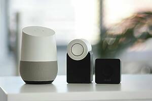 white and gray Google smart speaker and wo black speakers