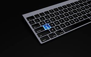 a black keyboard with a blue button on it